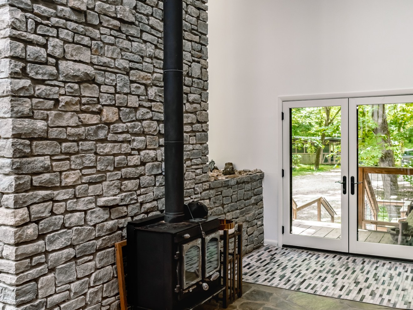 a stone building that has a bench in front of a brick wall